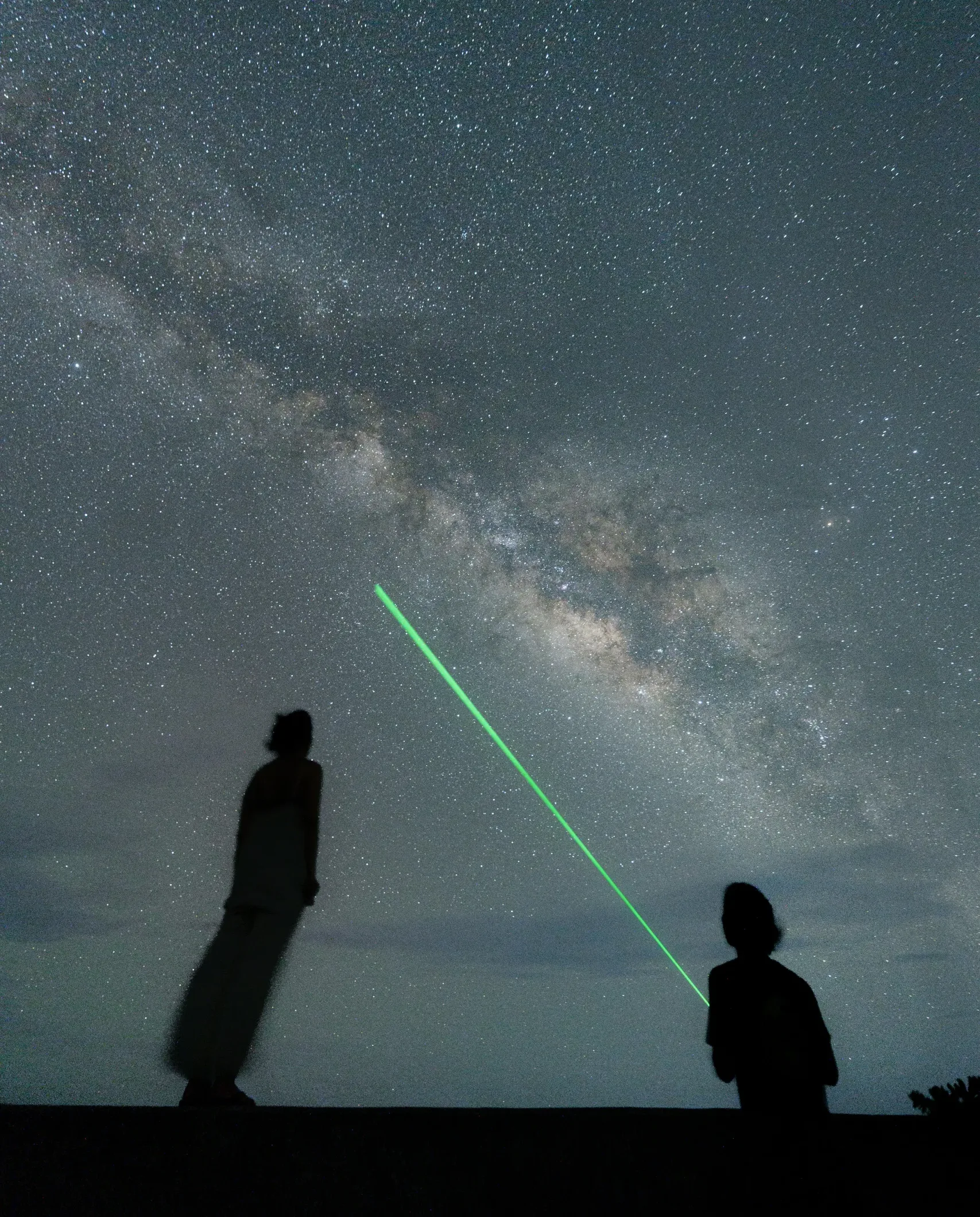 石垣島の星空の下で星座を指さすカップル。満天の星空フォトツアーの様子